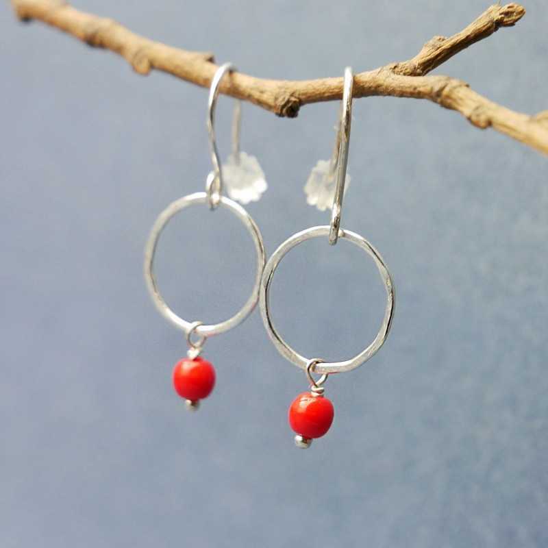 Minimalist round dangling earrings with a small red glass bead in u...